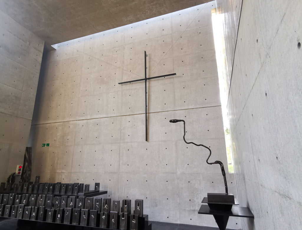The main concrete wall of the Church of the Wind with its single cross