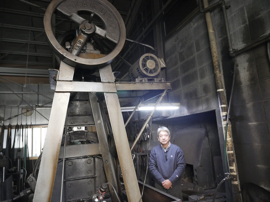 Tsukasa Hinoura standing beside the power hammer in his Sanjo workshop, April 2016