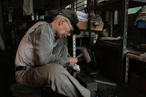 Keijiro Doi finishing a blade at the anvil in his Sakai forge, photographed by Suisin