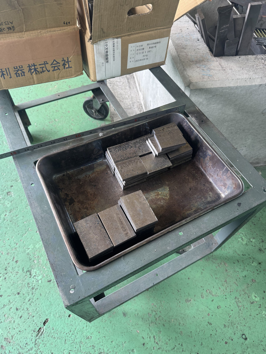 Trays of cut steel blanks waiting on the bench